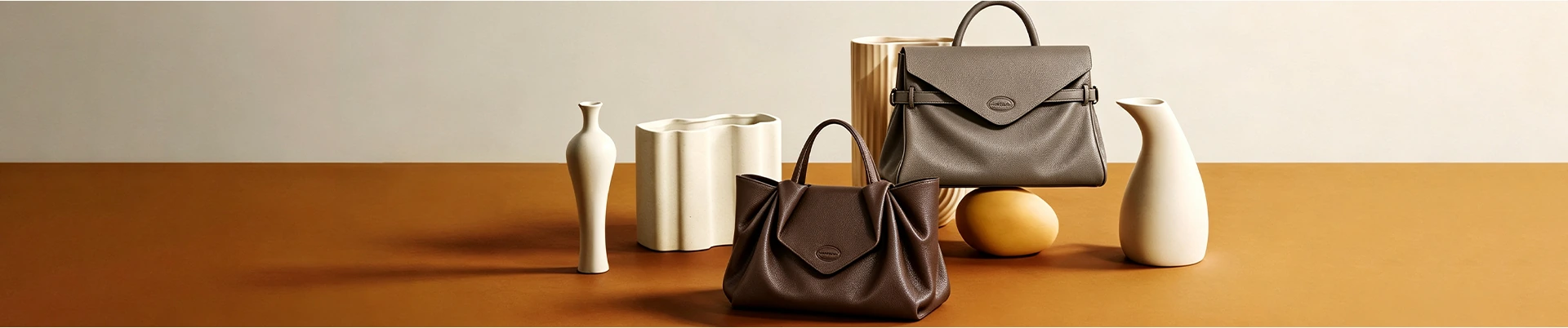 ORMA leather handbags arranged in a warm studio setting